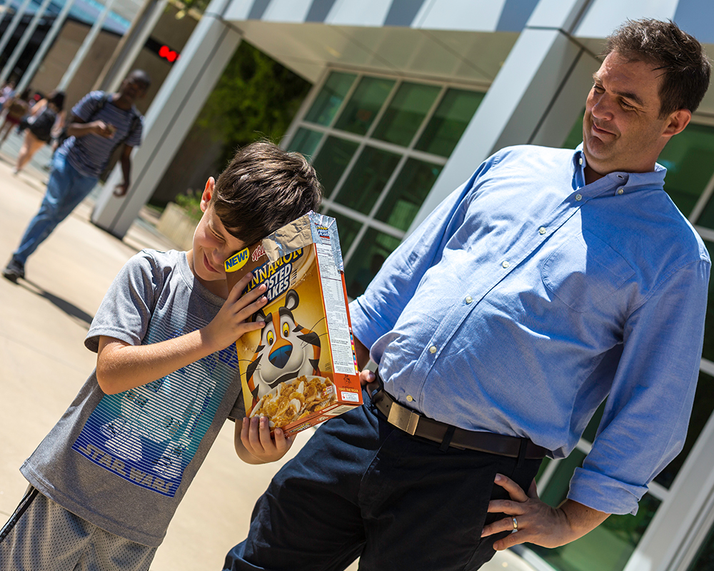 Debate program director Scott Herndon helped his son Liam construct a pinhole projector to view the solar eclipse.